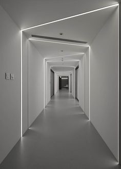 an empty hallway with white walls and lights