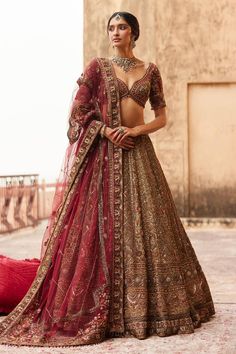 a woman in a brown and red lehenga