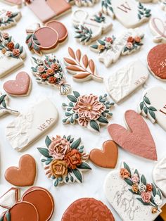 many decorated cookies on a table with flowers and hearts