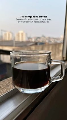 a cup of coffee sitting on top of a window sill