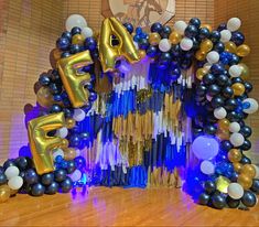 balloons and streamers are arranged in the shape of an arch