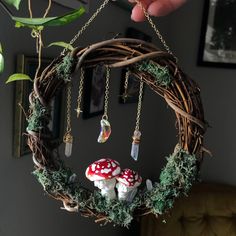 a hand holding a wreath with mushrooms hanging from it