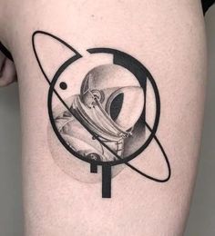 a tattoo on the back of a woman's thigh with an astronaut and saturn symbol