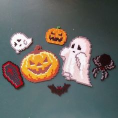 halloween decorations made out of perler beads and bead on a green table top