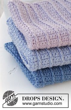 three crocheted dishcloths stacked on top of each other in blue and purple