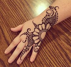 a woman's hand with henna tattoos on it