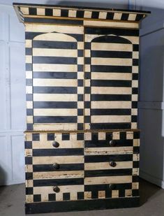 an old black and white striped cabinet with drawers