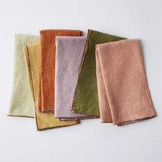 five different colored napkins on a white surface