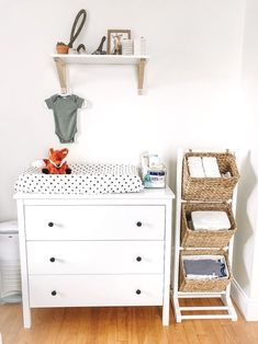 a baby's room with a dresser, changing table and toy bear on it