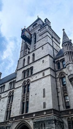 a large building with a clock on the top of it's tower and sky in the background