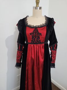 U.S. dress size 4-8 (medium). Italian renaissance 1490's style dress made from black velvet and red silk.  Adjustable lace back for a perfect fit.  Dress front features lace applique with hand beadwork. The lower sleeves are detailed with hand embroidery and glass beads.  Bust: 33"-40" Underbust: 33"-36" Underbust to hem: 42" Elegant Red Medieval Dress With Historical Design, Red Victorian Dress With Fitted Bodice, Red Formal Dress With Historical Design, Elegant Red Victorian Dress With Fitted Bodice, Fitted Gothic Victorian Dress With Lace Trim, Elegant Red Victorian Dress With Historical Design, Fitted Red Dress With Historical Design, Elegant Medieval Costume Dress In Red, Elegant Red Medieval Dress Costume