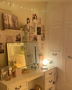 a white desk topped with a mirror and lots of pictures