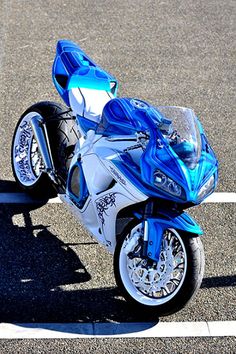 a blue and white motorcycle parked in a parking lot