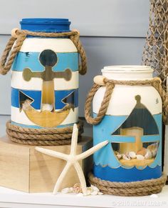 two blue and white painted jars sitting on top of a wooden box next to a starfish