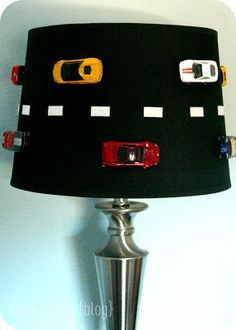 a lampshade with cars on it is hanging from the wall next to a lamp