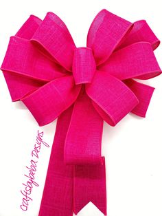 a large pink bow on top of a white surface with the words happy birthday written below it