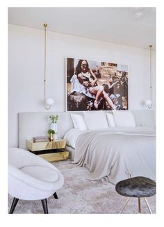 a bedroom with a bed, chair and pictures on the wall