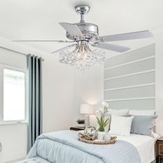 a bed room with a neatly made bed and a ceiling fan