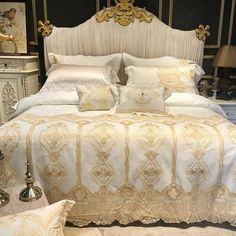 a white bed with gold trim and pillows