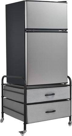 a silver refrigerator sitting on top of a metal cart next to two drawers with black handles