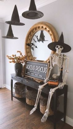 halloween decorations with skeletons and witches hanging from the ceiling, in front of a mirror