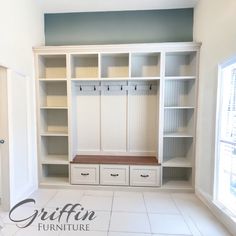 an empty room with white cabinets and drawers