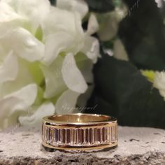 a close up of a wedding ring with flowers in the background