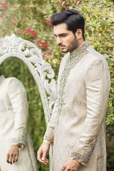 Adorn yourself in an ivory jamawar sherwani ensemble. Explore traditional Indian achkan styles paired with designer elegance. Ideal for weddings, the Nehru jacket adds a touch of sophistication to your attire.Crafted to embody the fusion of heritage and contemporary style, this groom's ensemble exudes sophistication and elegance. The classic ivory jamawar sherwani is adorned with exquisite zardozi embellishments on the sleeves, collar, and front, seamlessly blending traditional craftsmanship wit Wedding Turban, Groom Sherwani, Ivory Colour, Nehru Jacket, Sophisticated Wedding, Nehru Jackets, Groom Outfit, Groom Dress, Traditional Indian