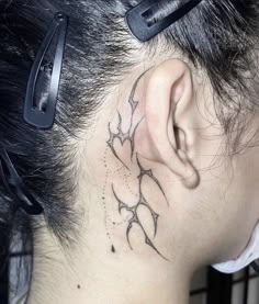 a woman with a tattoo behind her ear