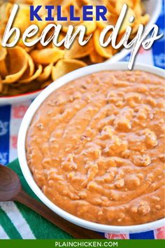 a white bowl filled with baked beans next to a plate of tortilla chips