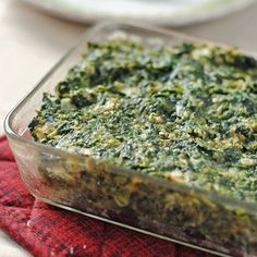 a casserole dish with spinach and cheese in it on a red napkin