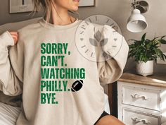 a woman wearing a sweatshirt that says sorry, can't watching phily bye