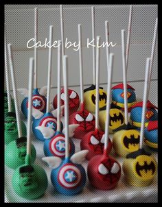 a bunch of cake pops that have been decorated with batman and captain america logos on them