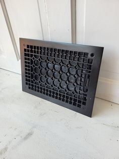 a metal grate sitting on top of a white floor next to a door way