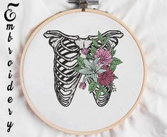 a cross stitch pattern with flowers in the shape of a rib cage on a white sheet