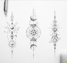 three different designs on a wall next to a pen and paper with the same drawing