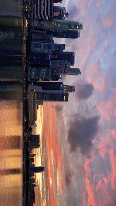 the city skyline is shown at sunset with clouds in the sky