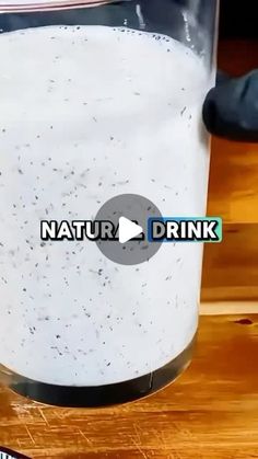 a glass filled with liquid sitting on top of a wooden table