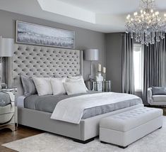 a bedroom with a large bed and chandelier