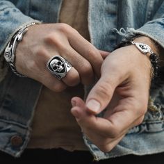 a person wearing two different rings on their fingers and holding the other hand with both hands