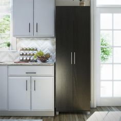 a kitchen with white cabinets and wood floors