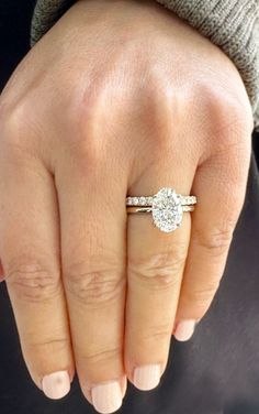 a close up of a person's hand with a diamond ring on their finger