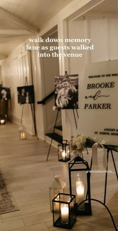 candles and signs are placed on the floor in front of a wall with an inscription that reads, walk down memory lane