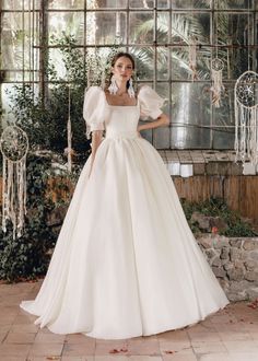 a woman in a white wedding dress posing for the camera