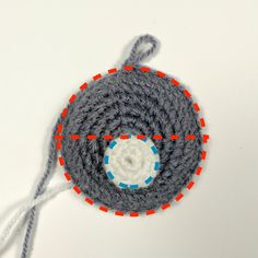 a crocheted object on a white surface with red and blue circles around it