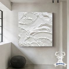 a painting on the wall next to a window in a room with white walls and flooring