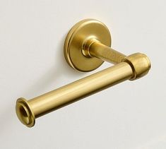 a gold toilet roll holder on a white wall