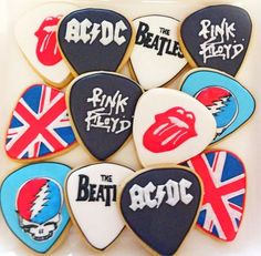 decorated cookies are arranged in the shape of guitar picks with different british symbols on them