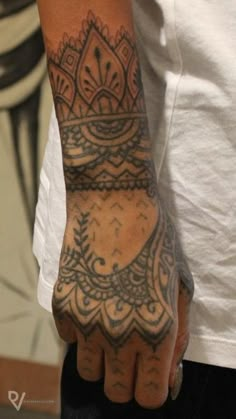 a person with a tattoo on their arm and hand holding something in the other hand