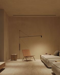 a room with two beds, a chair and a lamp on the wall in it